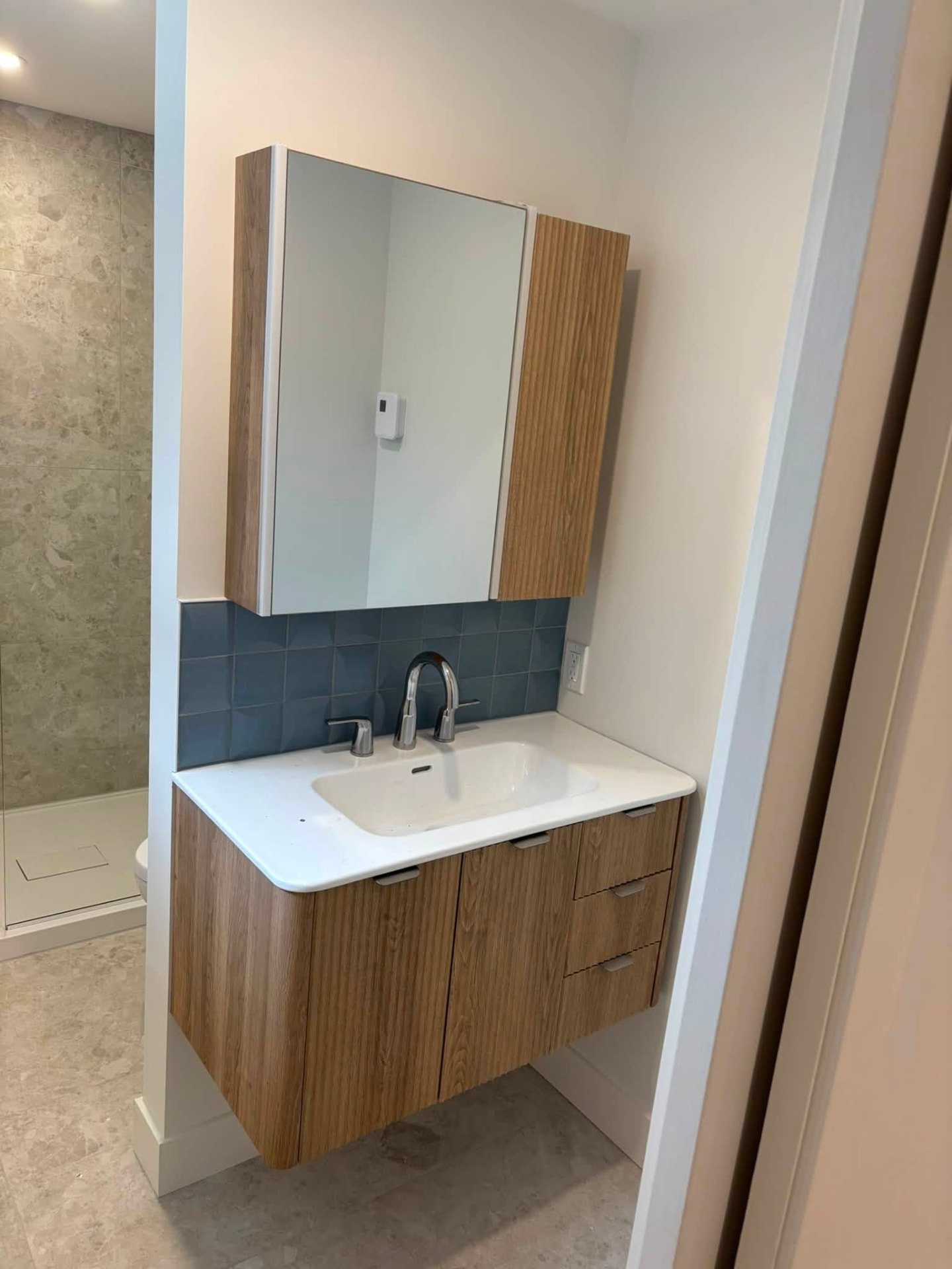 Vanité de salle de bain suspendue en bois avec dosseret de tuiles bleues